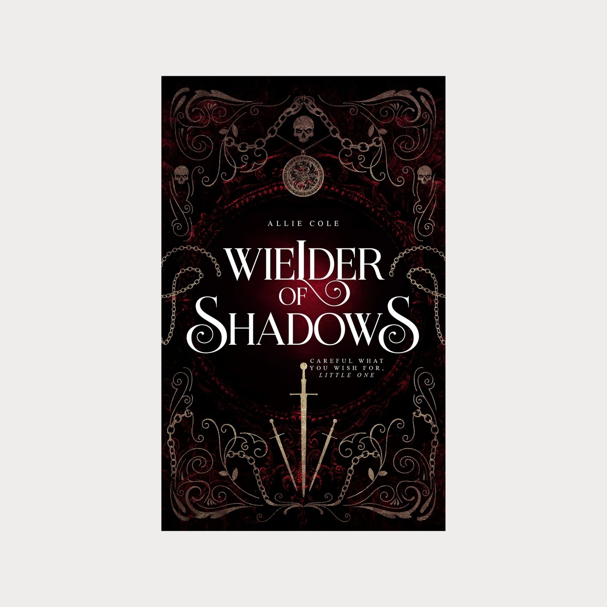 Hardcover edition of Wielder of Shadows by Allie Cole, a dark fantasy romance novel. The cover features gothic filigree, chains, skulls, and a glowing red background, with a silver sword at the center. The tagline reads Careful what you wish for, little one